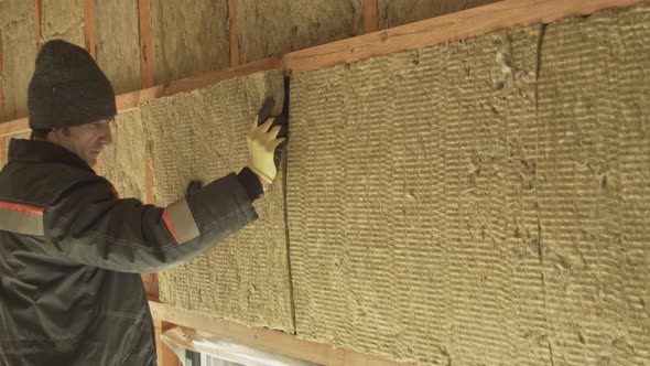 Man Laying Insulation in a Wall