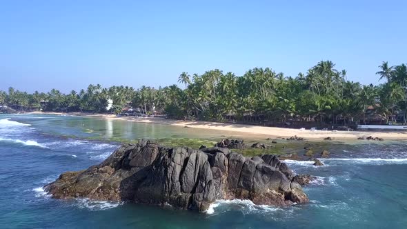 Young Woman Meditates on Cliff Between Ocean and Beach alt