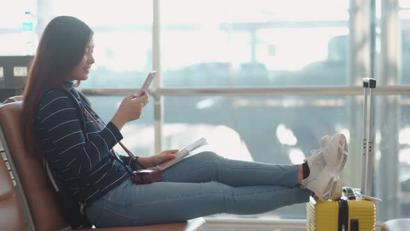 Young female traveler using smartphone at airport