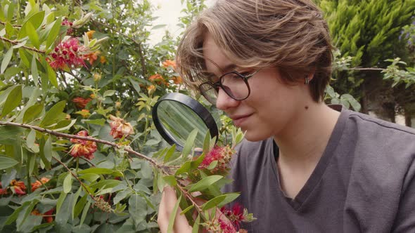 Young Girl Examines Flowers With A Magnifying Glass 2 alt