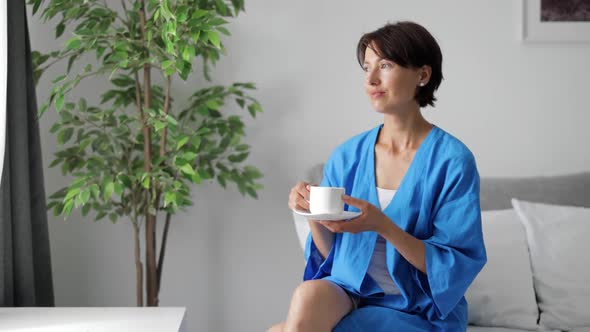 Woman Drinking Coffee in Bedroom