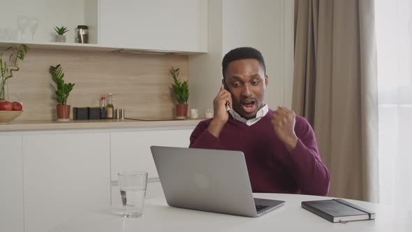 Young 20s African American Black Sales Manager Talking on a Phone and Achieves a Sale Happy and alt