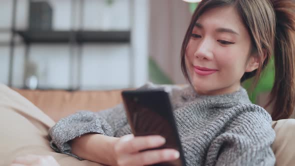 social media enjoy,asian female adult smile laugh hand seach surf smartphone device alt