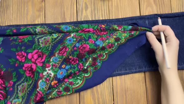 Women's Hands Apply Patterned Fabric to Denim Pant Leg and Draw Mark