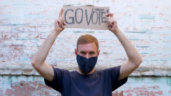 Man shows cardboard Go Vote sign Make the political choice Use your voice Presidential elections 4K