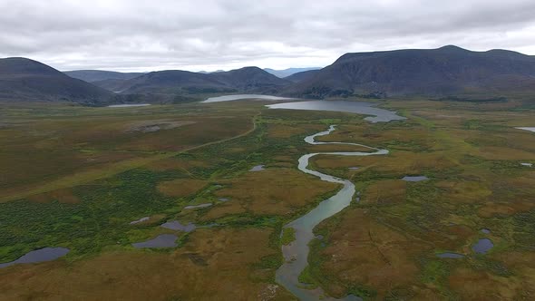 Flying Over River In Tundra To Mountains