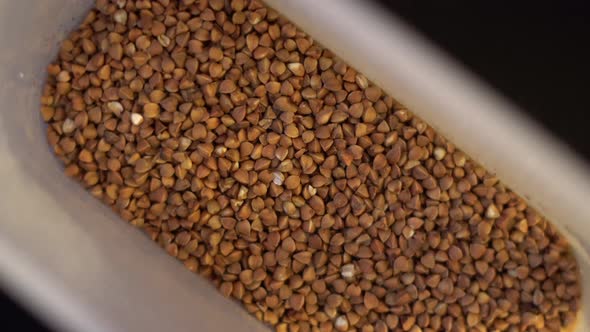 Raw Buckwheat is Whirled in a Plastic Container alt