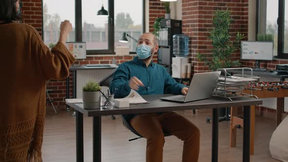 Workmates Doing Fist Bump Before Work in Startup Office alt