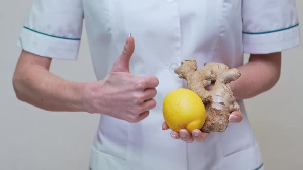 Nutritionist Doctor Healthy Lifestyle Concept - Holding Ginger Root, Lemon and Vitamin Pill alt
