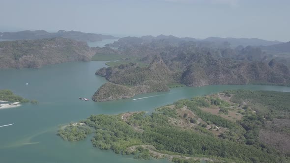 Aerial view of valley river, floating boat, mountains. Kilim Geoforest Park, Langkawi, Malaysia