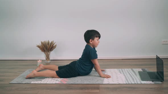Caucasian Boy Does Yoga Online Child Performs Gymnastic Exercises Yoga for Beginners Upward Acting