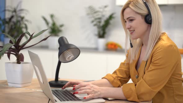 Woman Working with Laptop in Bright Kitchen alt