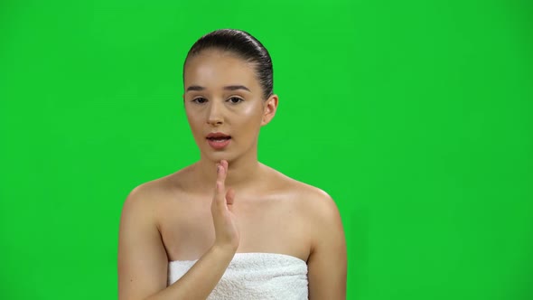 Girl in Towel Looks Around, Covers Her Mouth with Her Hand and Whispers the Secret on Green Screen alt
