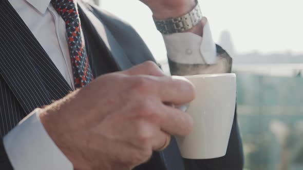 Businessman Talks on the Phone and Drinks Coffee.