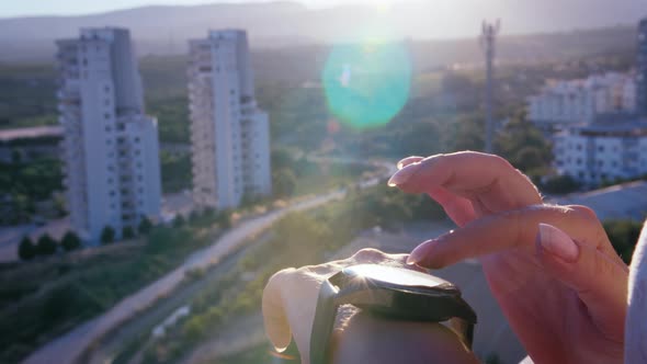 Woman Using Smart Watch Closeup at Sunset on the Balcony