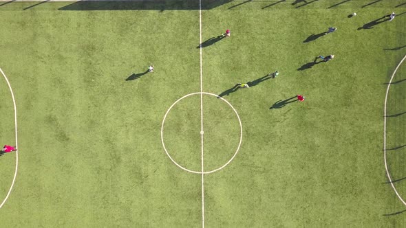 Top down aerial view of green football sports field and players playing football.  alt