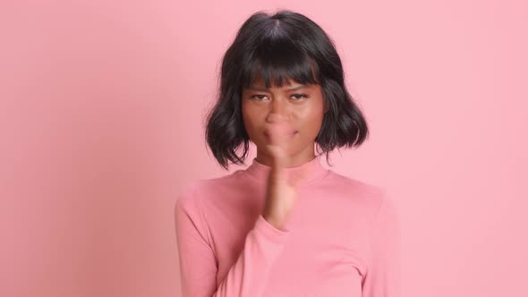 Woman Waves Palm Near Nose Smells Unpleasant Stench Over Pink Background alt