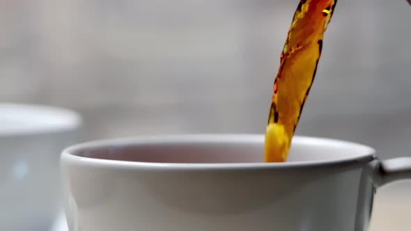 pouring freshly brewed fragrant dried green tea leaves into a mug. mug close-up.