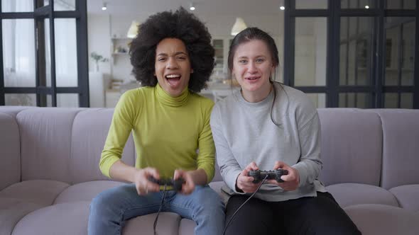 Portrait of Young Joyful Female Gamers Giving Highfive Playing Multiplayer Video Game alt