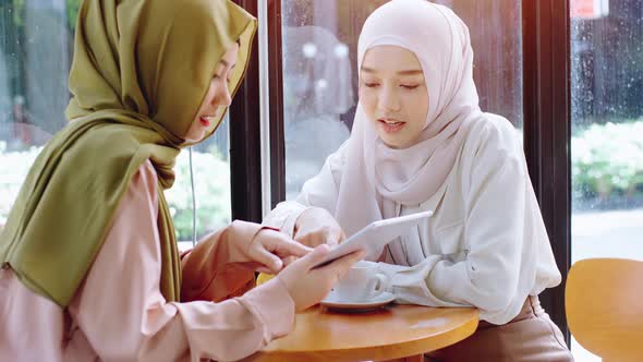 Young beautiful Asian Muslim women enjoying a relaxing moment working and playing with mobile phone alt