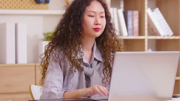 Asian girl finished computer work,  stretching relaxing seated at workplace feeling stress relief, s alt