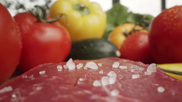 Zoom out macro video of sea salt on raw steak. Shot with RED helium camera in 8K alt