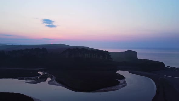 Aerial drone birds eye view of coastal beach landscape at twilight sunrise, Devon England alt
