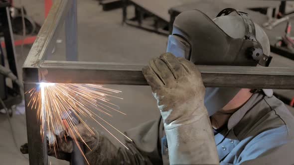 Workman In Workshop. Welding Process. A Welder In Helmet Doing His Job. 