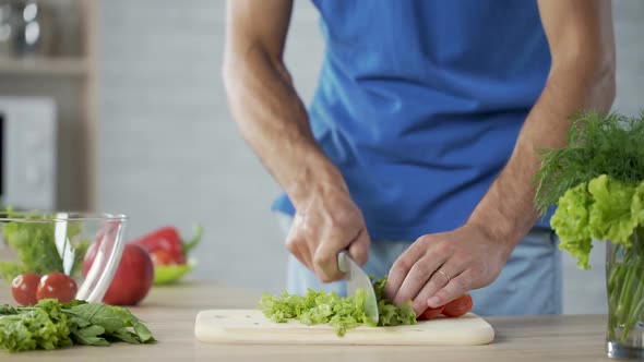 Male Preparing Vegetable Salad Carefully Controlling His Health and Nutrition alt