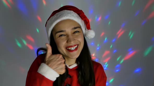 Close-up Portrait of a Young Happy Woman, She in a Festive Mood Tries on a Santa Claus Costume