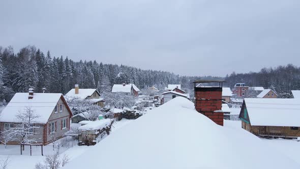 Flying Above Roof with Chimney Revealing Snowy Village alt