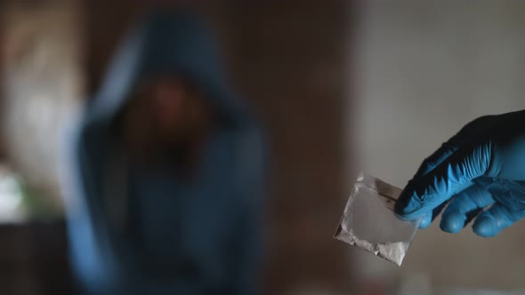 Drug Trafficking in Glove Holding Heroine in Bag and Person on Background Refusing To Take alt
