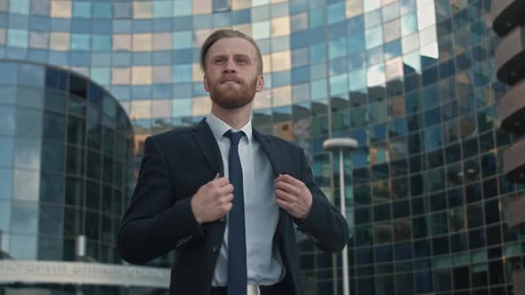 Goodlooking Confident Purposeful Adult Bearded Businessman in Stylish Suit Comes Out of the Office