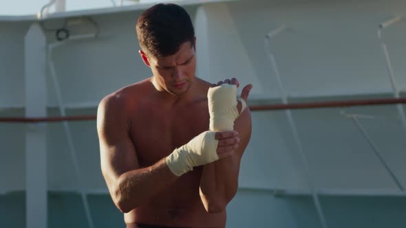 Athletic Man Puts on Hands Wraps for Boxing Workout
