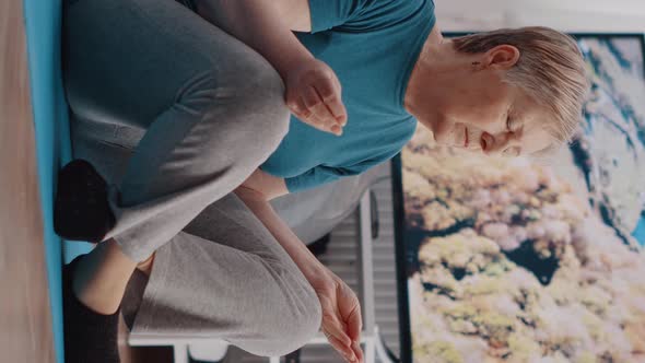 Vertical Video Elder Person Sitting in Lotus Position on Yoga Mat to Meditate alt