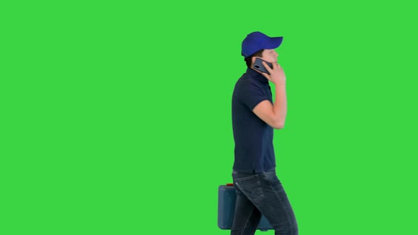 Handyman with a Toolbox Calls Client After Finishing Work on a Green Screen Chroma Key
