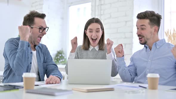 Ambitious Startup Team Celebrating Success on Laptop alt