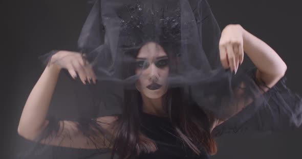 Mystical Woman in Black Veil Looking at the Camera and Smiles, the Celebration of Halloween alt