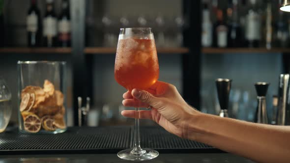 Aperol Spritz Cocktail with Orange Slices and Ice on Black Tray on Dark for Celebration Water Drops alt