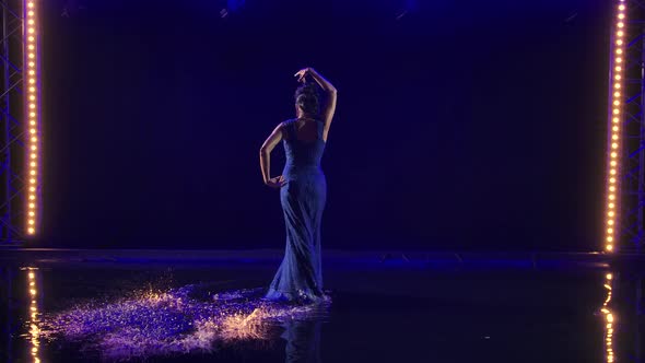 Attractive Sexy Woman Dancing Flamenco Elements in a Dark Studio on the Water Surface alt