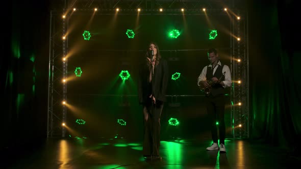 A Beautiful Girl Vocalist Languidly Singing and Gestures with His Hands on Stage in a Vintage alt