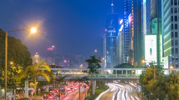 Hong Kong Street with Busy Traffic and Skyscraper Office at Dusk Day To Night Timelapse alt