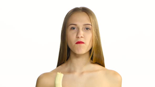 Girl with Braces and Red Lips Eating a Banana and Looking at the Camera, White, Closeup alt