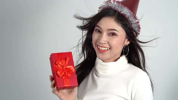 happy young woman with hat and holding a red Christmas gift box