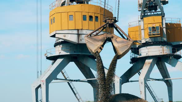 Crane with Bucket Unloads Rubble at Docks alt