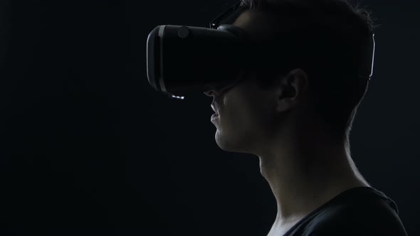 Closeup Shot of Man Getting Experience in Using VRheadset in Dark Room