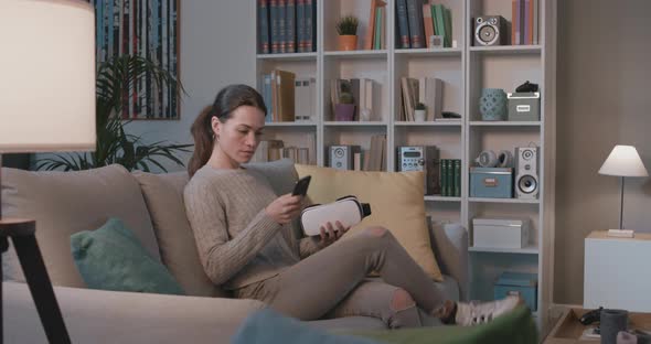 Young woman sitting on the couch and wearing a VR headset