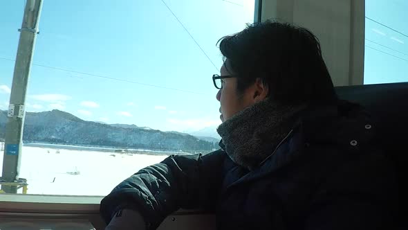 Asian Man Travel By Train On Winter alt