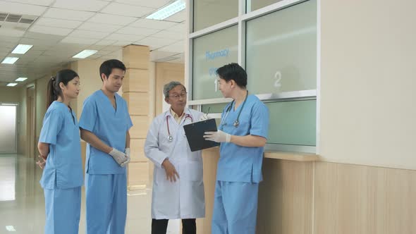Team of asian doctor nurse consult together on patients file at hospital. alt