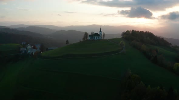 Amazing Beautiful Aerial View of the Hills, Colorful Forest and the Sv Sobota Church. Slovenia